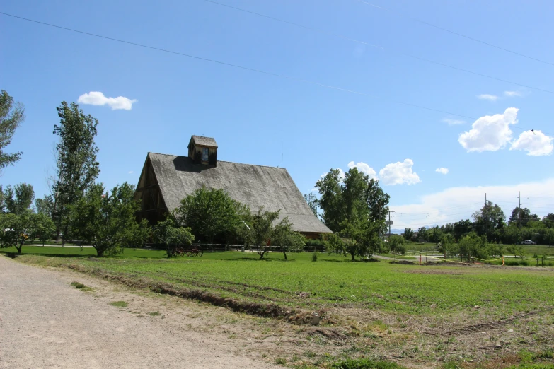 an old style farm house with a dirt driveway