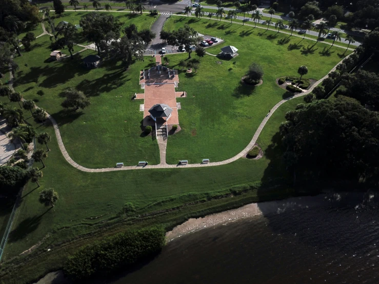 an aerial s of a home with a green field next to it