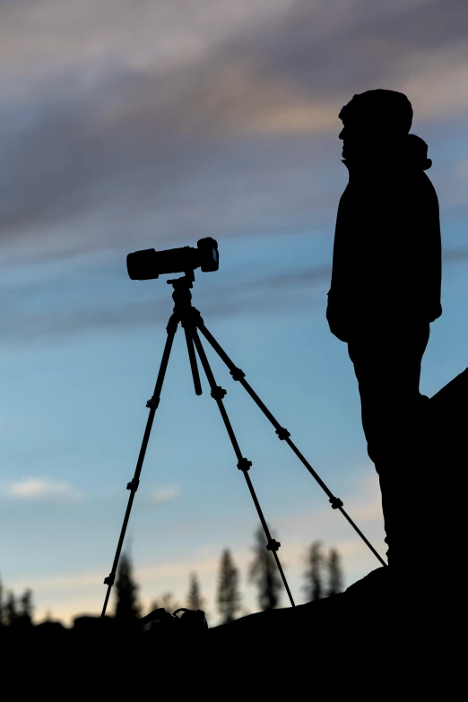 a man is standing next to a tripod