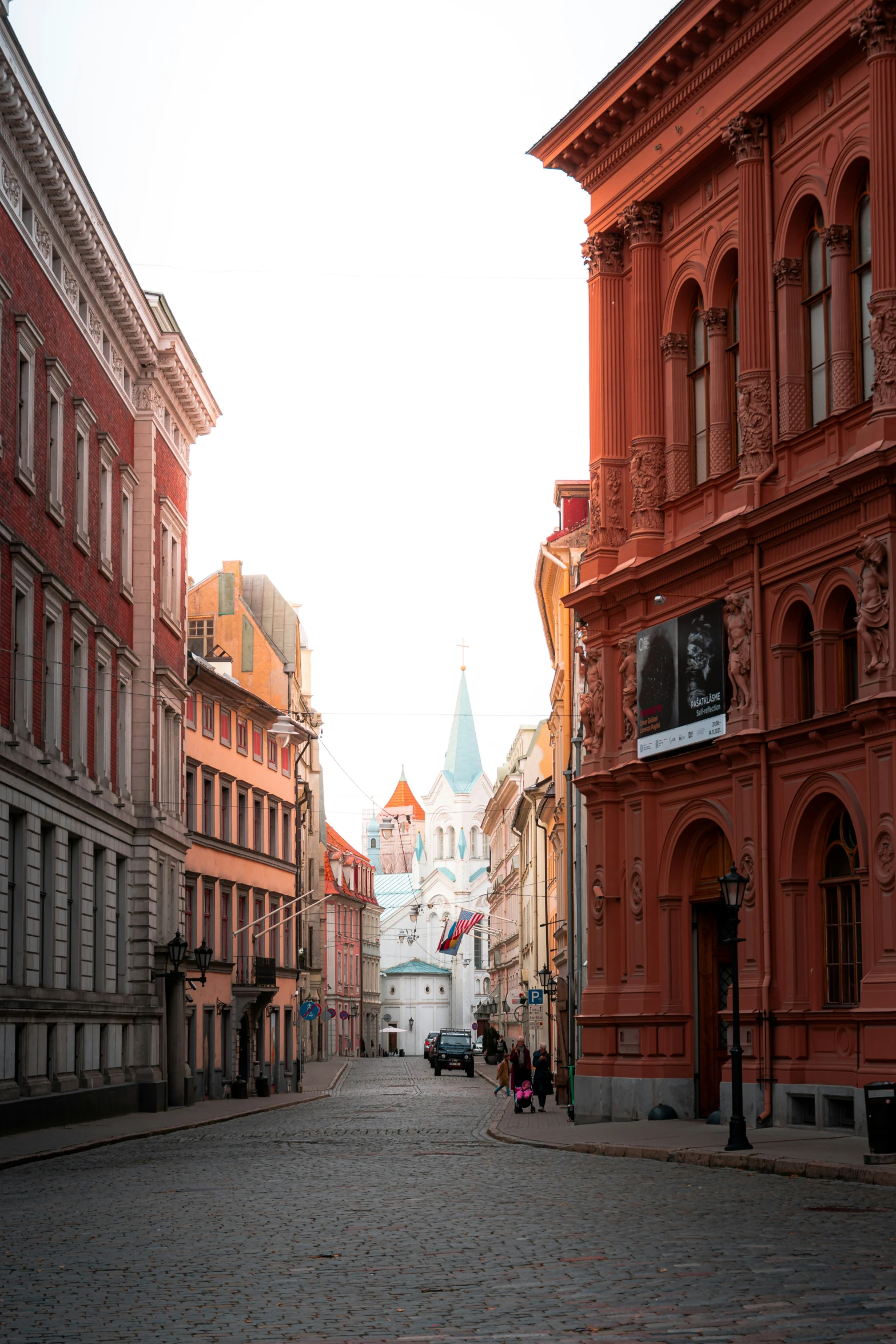 a narrow cobblestone road that is bordered by tall buildings