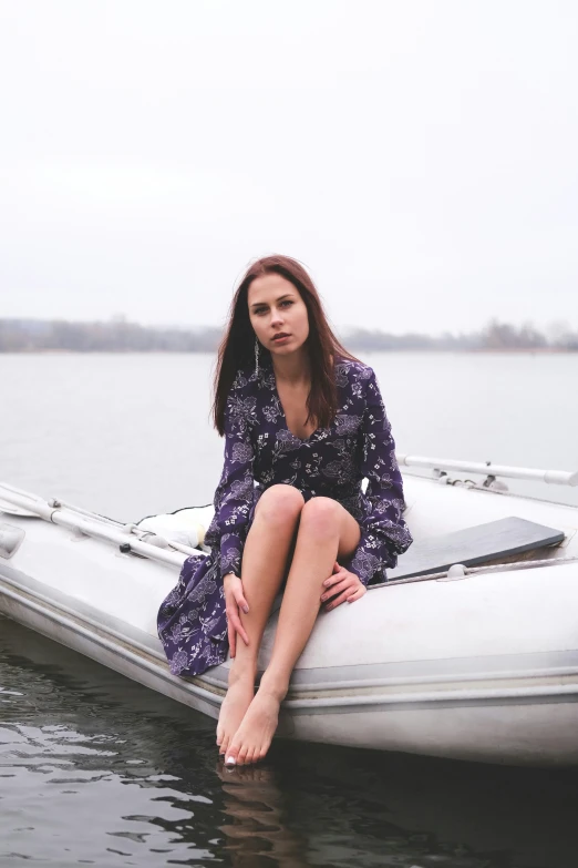 the young woman sits on the raft by the water