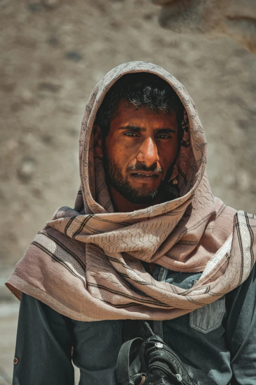 a man wearing a scarf looks down