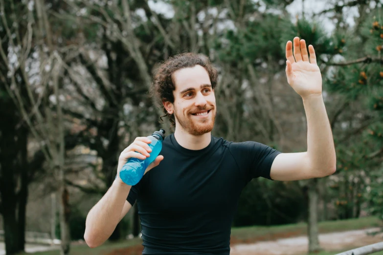 a man holding a water bottle in one hand and a plastic bottle in the other