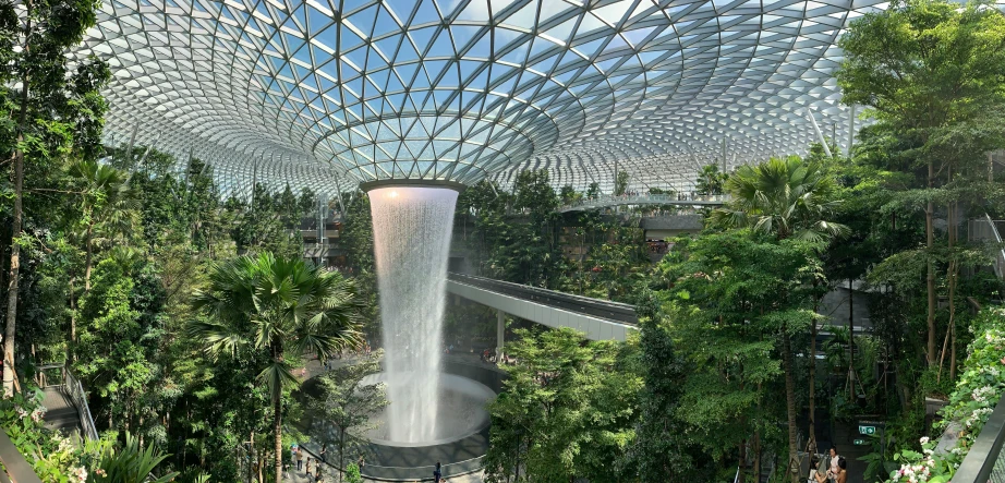 people walk down a covered walkway and an atrium