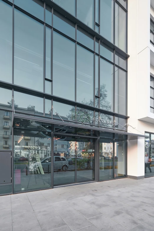 a building with glass windows that are reflecting cars