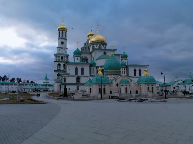 a large building with gold domes sitting on top of a sidewalk