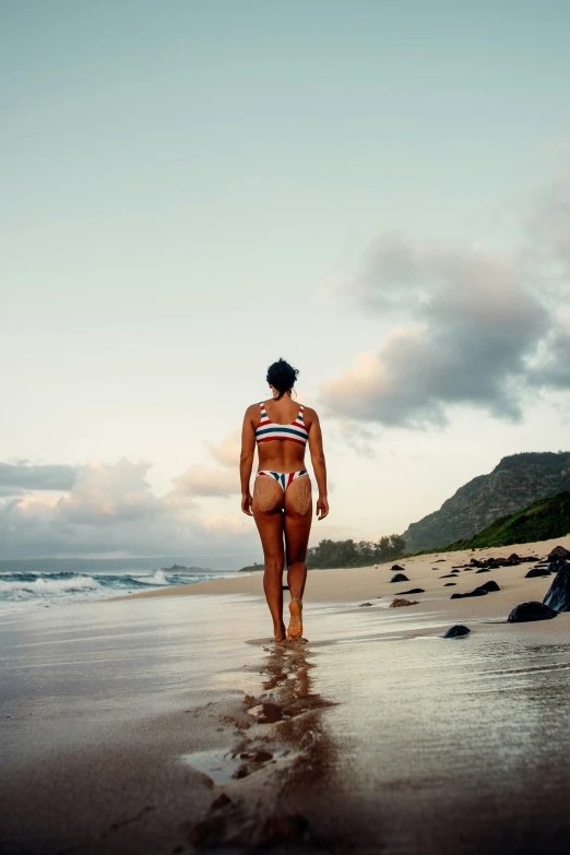 the young woman is wearing a bikini on the beach
