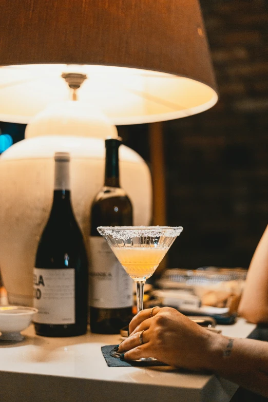 there is a martini on a counter with a woman at the table