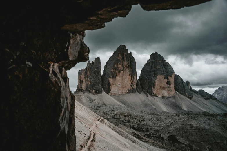 dark colored rocky mountains are shown through a window