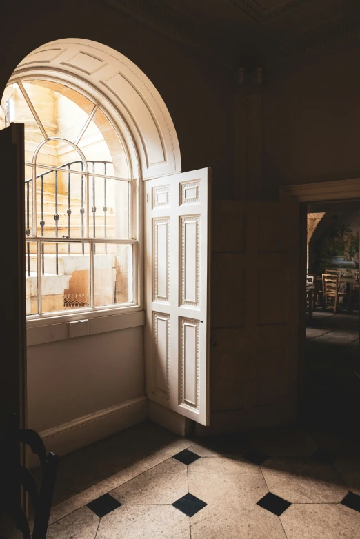 a room with a chair a window and some white doors