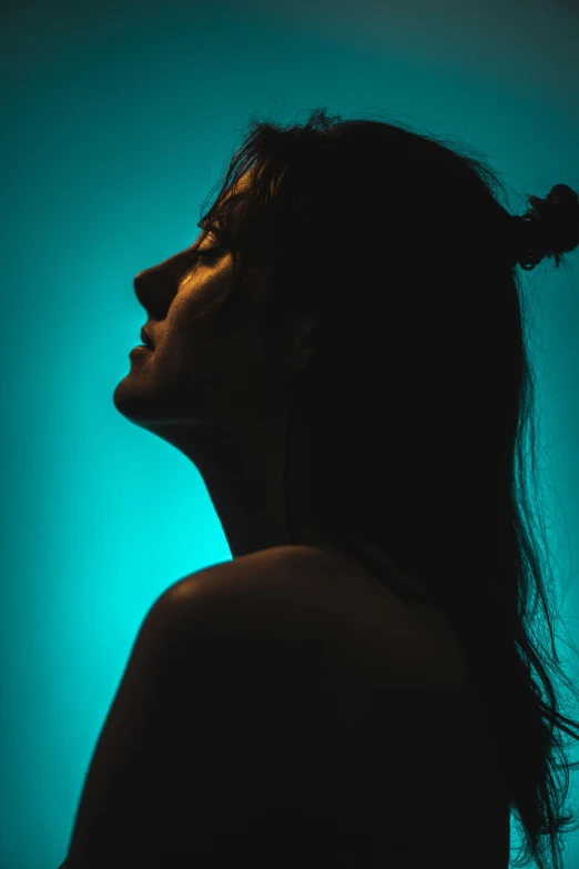 a woman standing up against a green and blue background