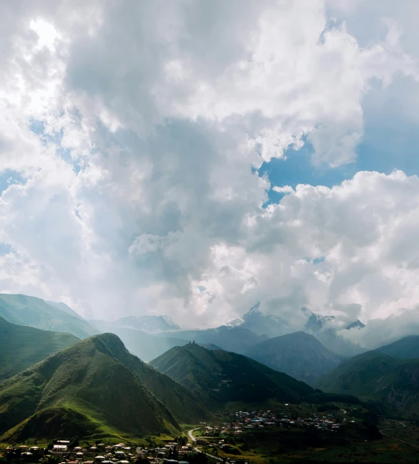 clouds over a mountain and town in the valley