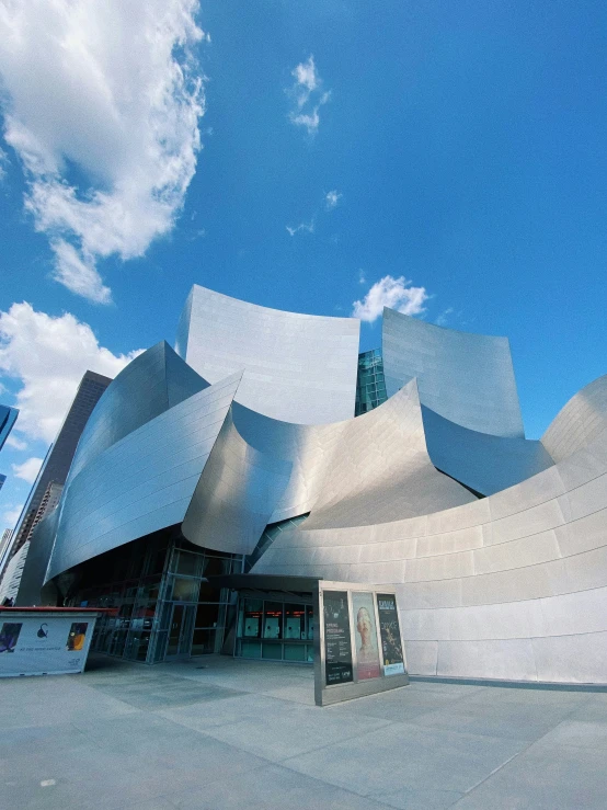 there is an artistic architectural building with the blue sky behind it