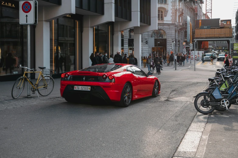 red sports car parked in a small alley