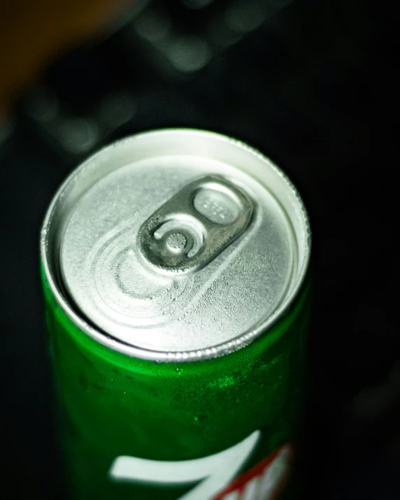 a can of coca - cola on the table with a remote control