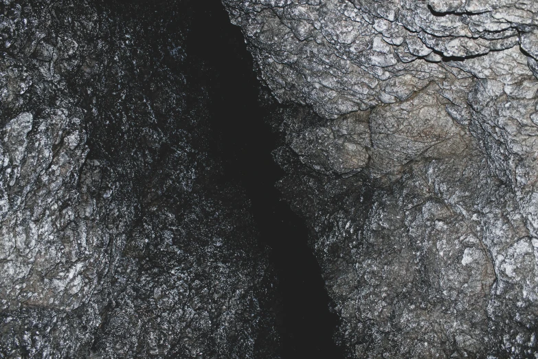 a black stone cliff with a very long river next to it