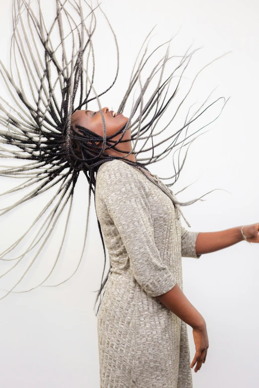 a woman with long hair stands near the wall