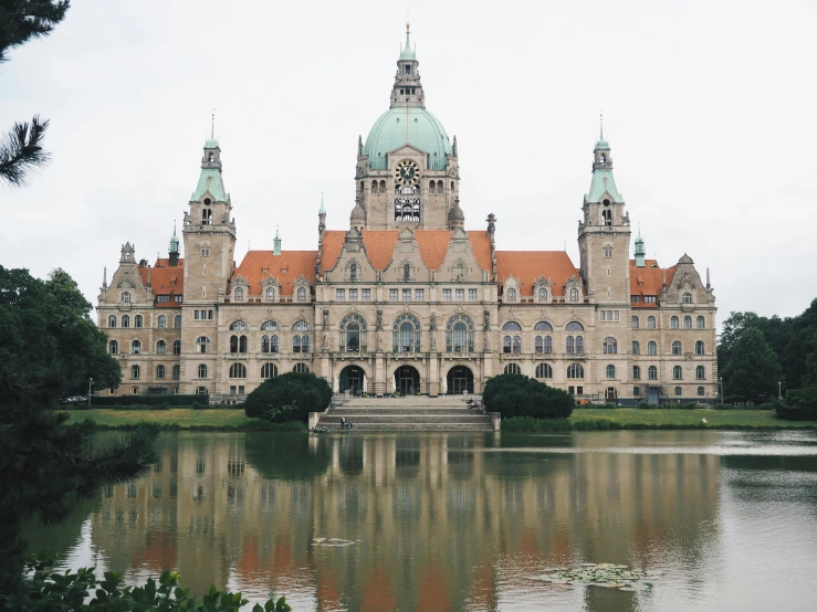 large stone building with a lake and a clock tower