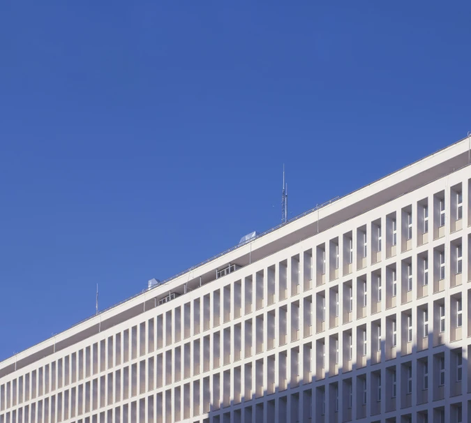 large beige building with two tall windows against a blue sky