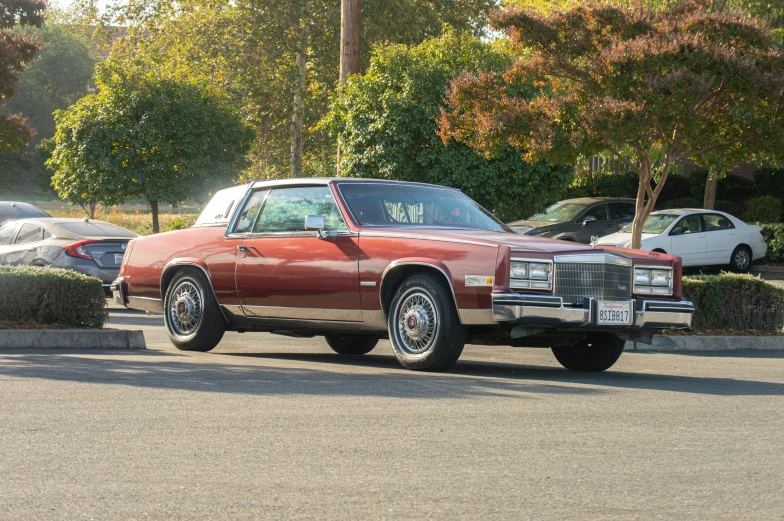 an old fashioned red car is parked in a parking lot