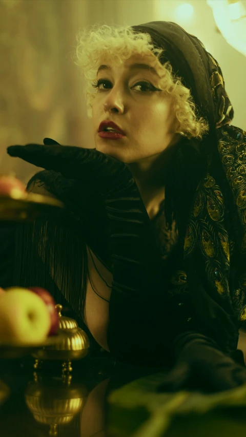 a beautiful woman in black with curly hair, sitting at a table