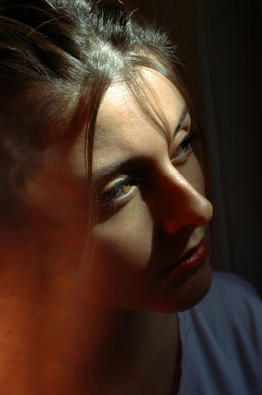 a woman looking over her shoulder with light on her face