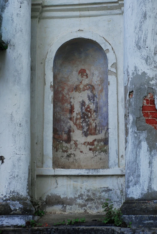 an old and crumbling wall with an arched window