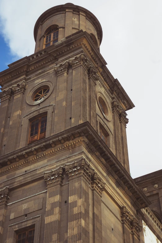 the tower is made of stone and has clocks on each window