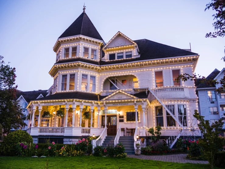 a victorian house with holiday lights on it