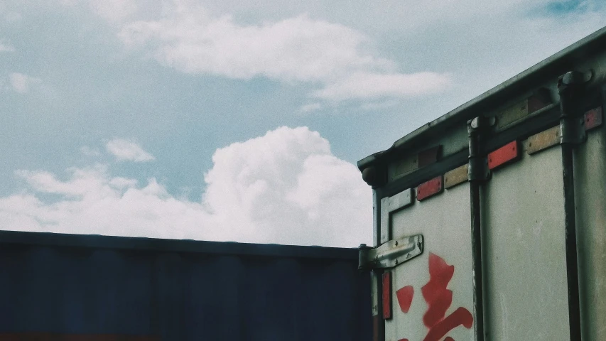 some red and blue train cars with some white clouds in the background