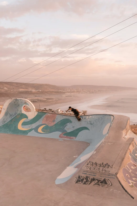 two men riding boards down a hill in a beach