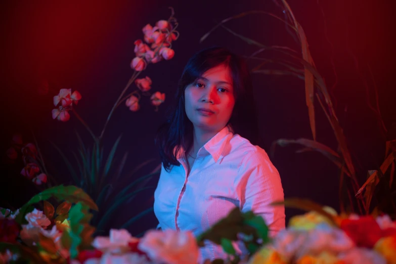 a girl sitting in a room with flowers on it