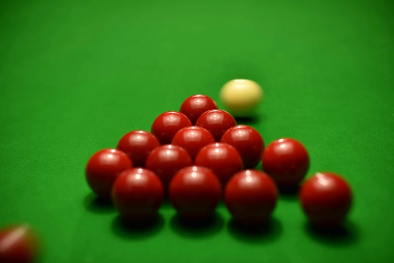 a group of red balls placed together on a pool table