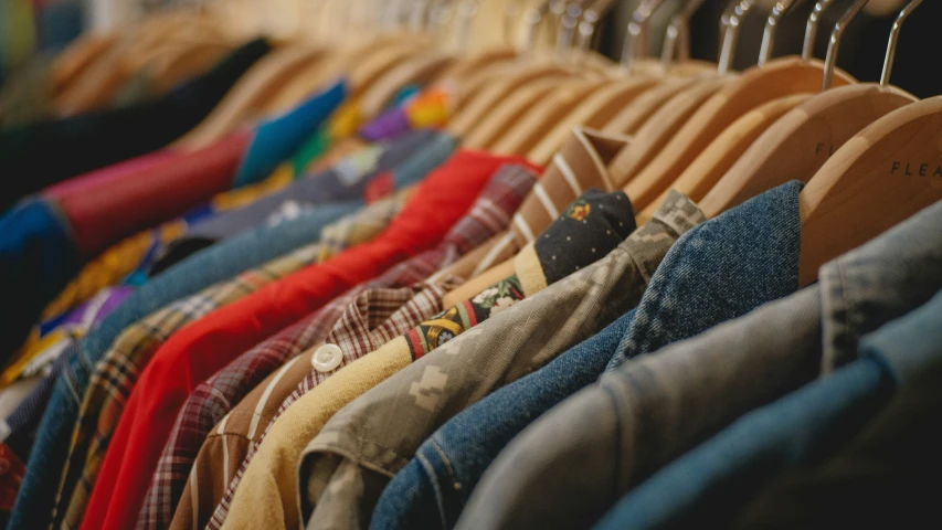 shirts and pants are hanging on racks in a rack