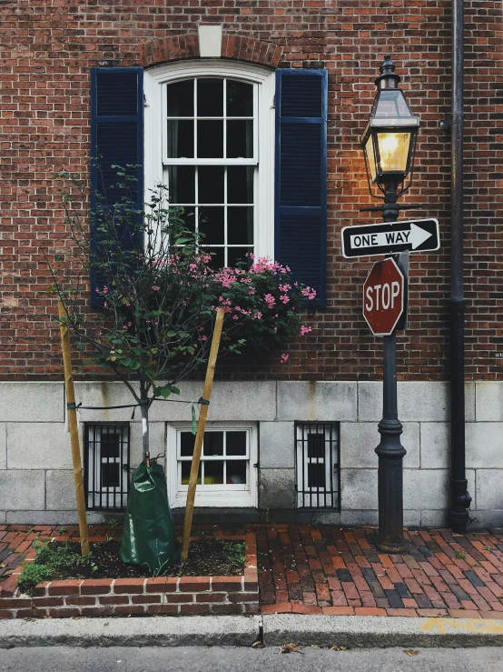 a stop sign sitting next to a street light on the side of a building