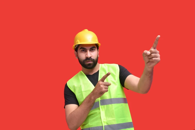 the man in the safety vest points a finger up