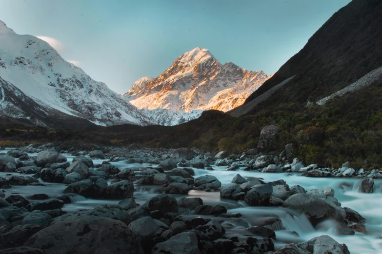 a view of a large mountain and water at sunset