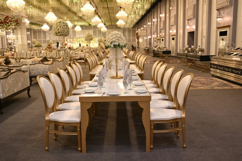 a restaurant with all white table settings and chandeliers