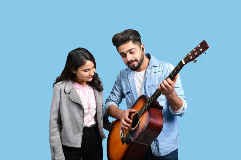 the man and girl are standing near an electric guitar
