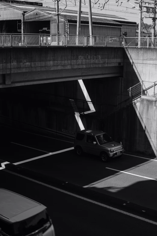 a small truck on an empty highway under the bridge