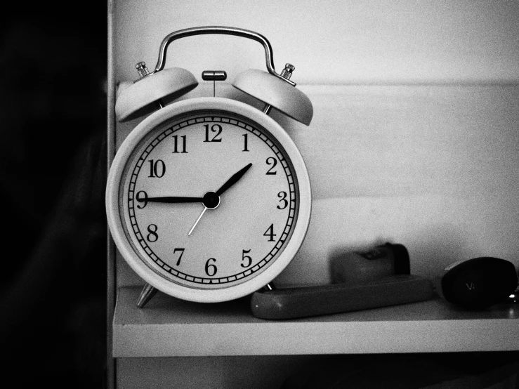 an old clock on a shelf on top of a wooden table