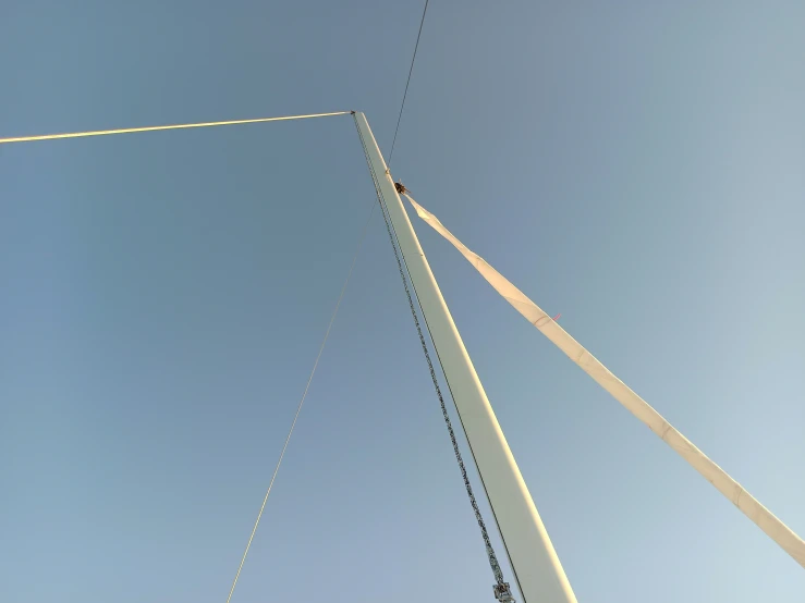 a man flying a kite next to a metal pole