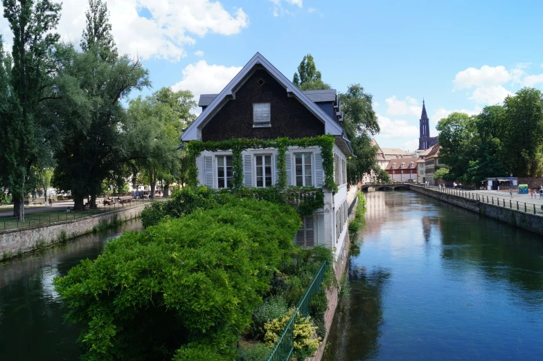 a house on the edge of water surrounded by trees