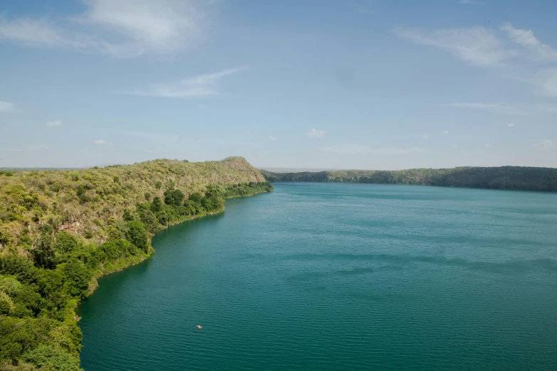 the water is green with little waves and blue sky