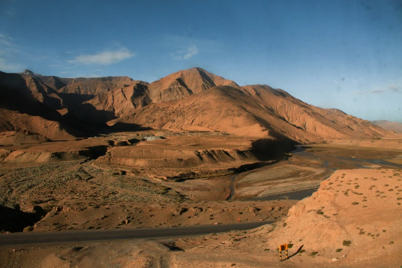 the desert landscape shows sp mountains and the road