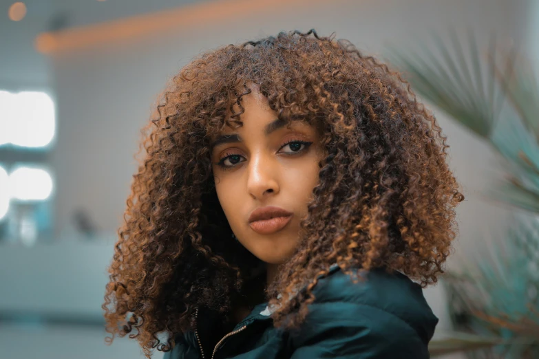 a woman with very curly hair poses for a picture