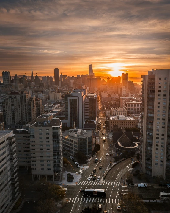 a sunset view of a city with a highway going through it