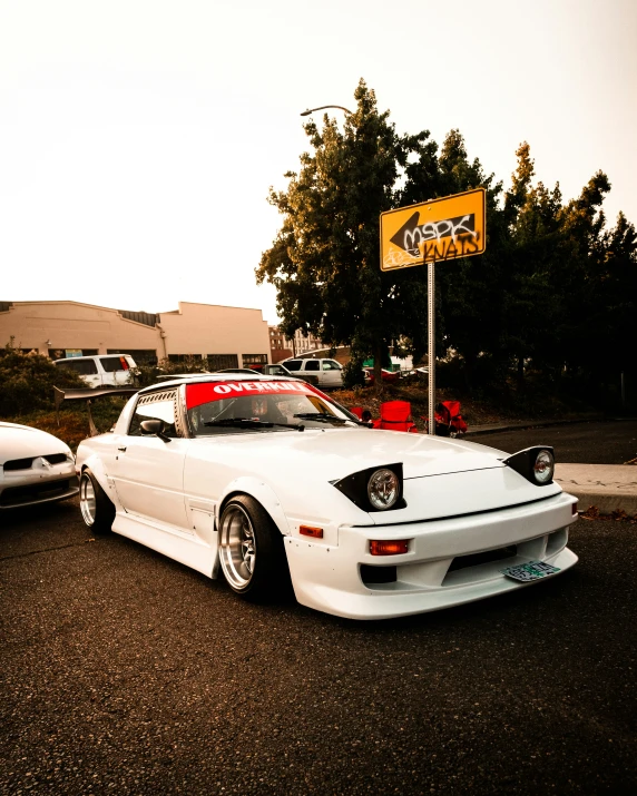 two white sports cars parked near each other on the street