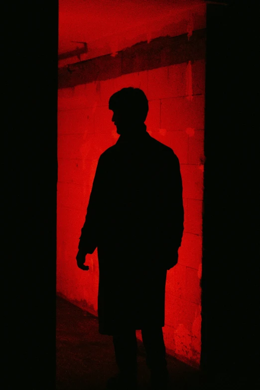 silhouette of a person standing in a darkened area