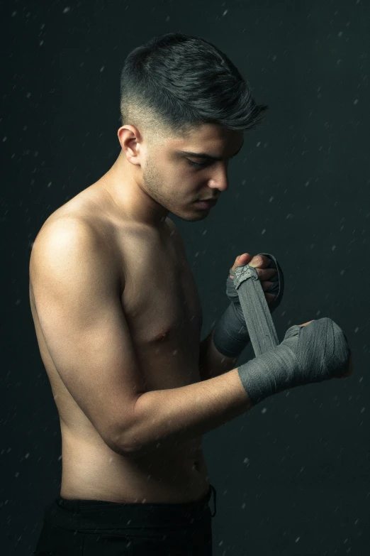 a man holding a pair of gray boxing gloves